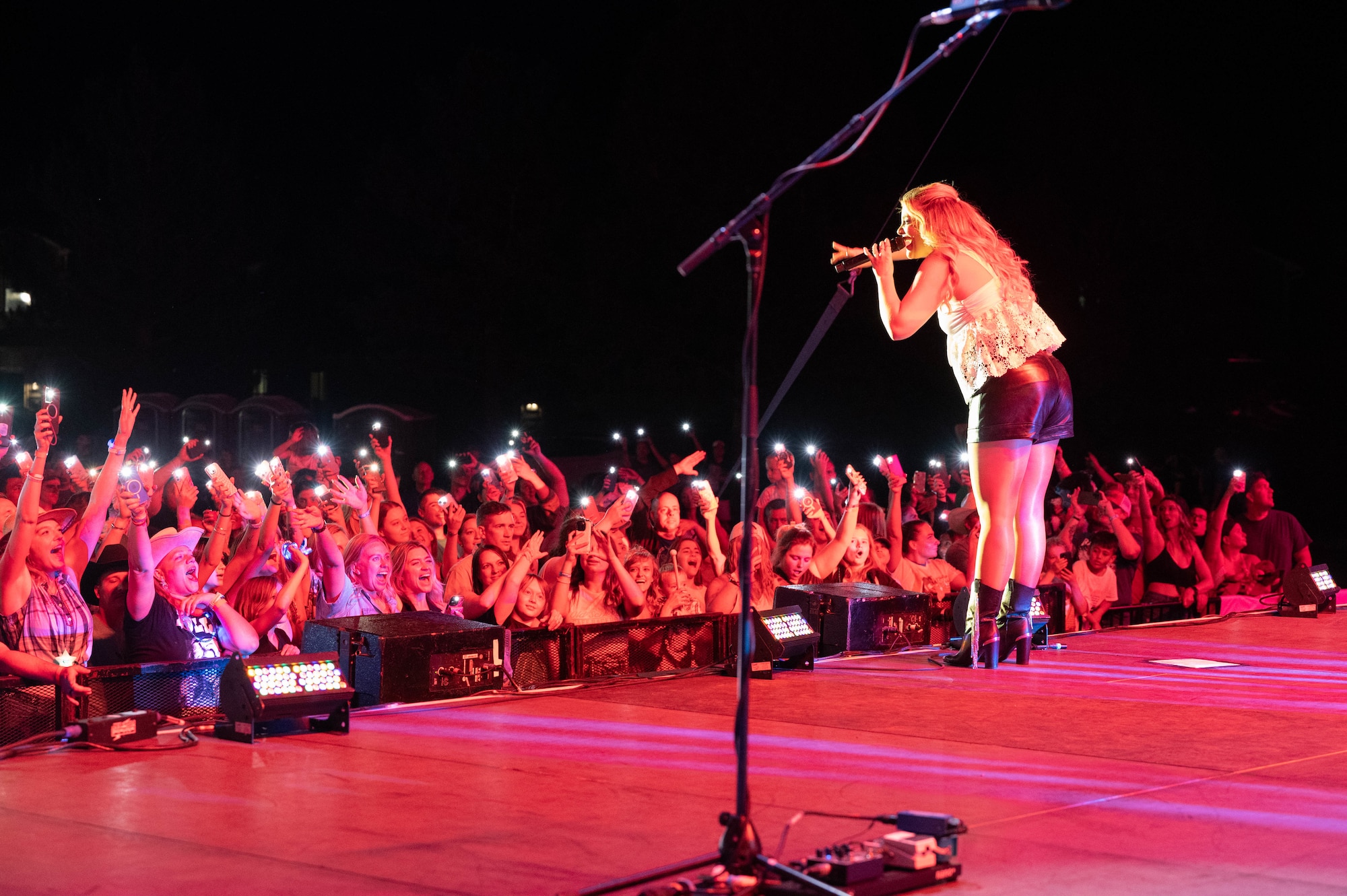 Lauren Alaina sings to the crowd by the edge of the stage