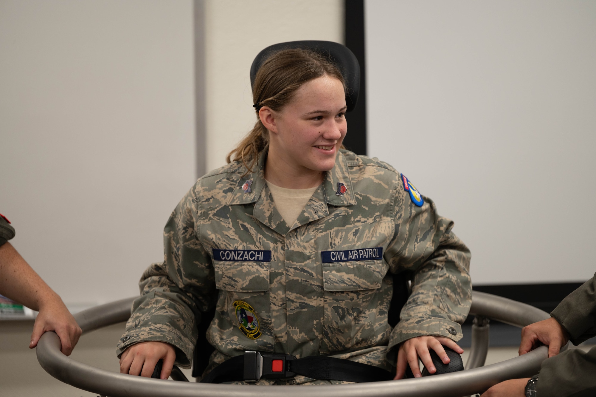 A cadet is listening as instructors explain spatial disorientation while sitting on the Barany chair.