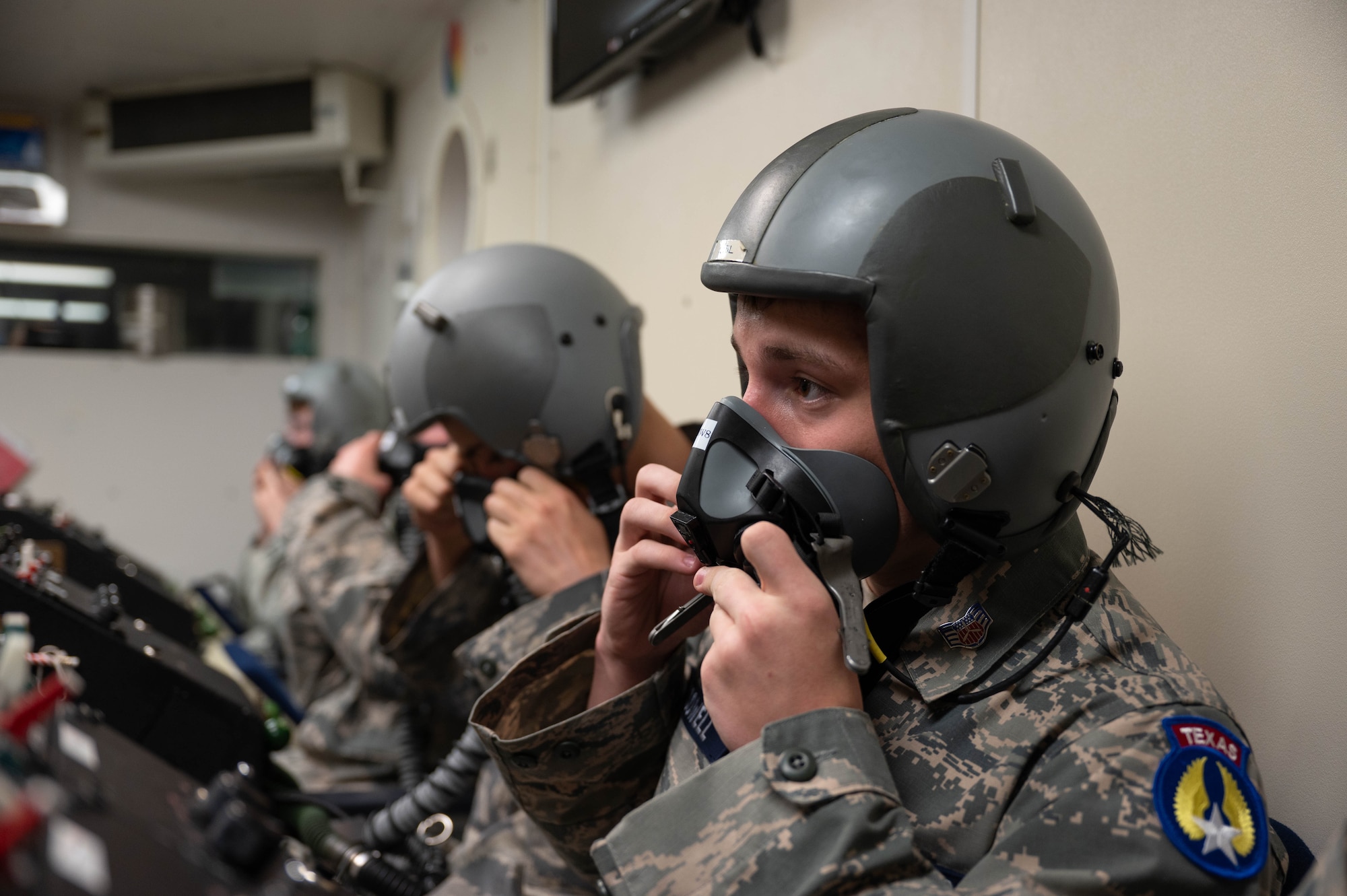 Cadets don a flight helmet and mask as they are explained how the altitude chambers works.