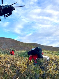 Alaska Air National Guard Maj. Dan Warren (right), 212th Rescue Squadron combat rescue officer, and Master Sgt. Harry Bromley, 212th RQS pararescueman, evacuate an injured airplane pilot Aug. 30, 2024, about 50 miles southwest of Tok to a 210th Rescue Squadron HH-60G Pave Hawk. Warren and Bromley jumped from a 211th Rescue Squadron HC-130J Combat King II to quickly reach the injured pilot.