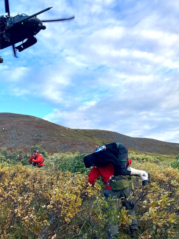 Alaska Air National Guard Maj. Dan Warren (right), 212th Rescue Squadron combat rescue officer, and Master Sgt. Harry Bromley, 212th RQS pararescueman, evacuate an injured airplane pilot Aug. 30, 2024, about 50 miles southwest of Tok to a 210th Rescue Squadron HH-60G Pave Hawk. Warren and Bromley jumped from a 211th Rescue Squadron HC-130J Combat King II to quickly reach the injured pilot.