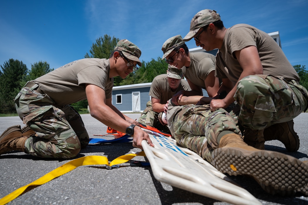 U.S. Air Force medical Airmen with the Air National Guard transfer a simulated patient onto a litter during a tactical combat casualty care course at Alpena Combat Readiness Training Center, Alpena, Michigan, June 11, 2024. The course was part of Medical Readiness University, an Air National Guard-hosted two-week event offering multiple courses providing medical Airmen with hands-on operational training. (U.S. Air National Guard photo by Tech. Sgt. Sarah M. McClanahan)