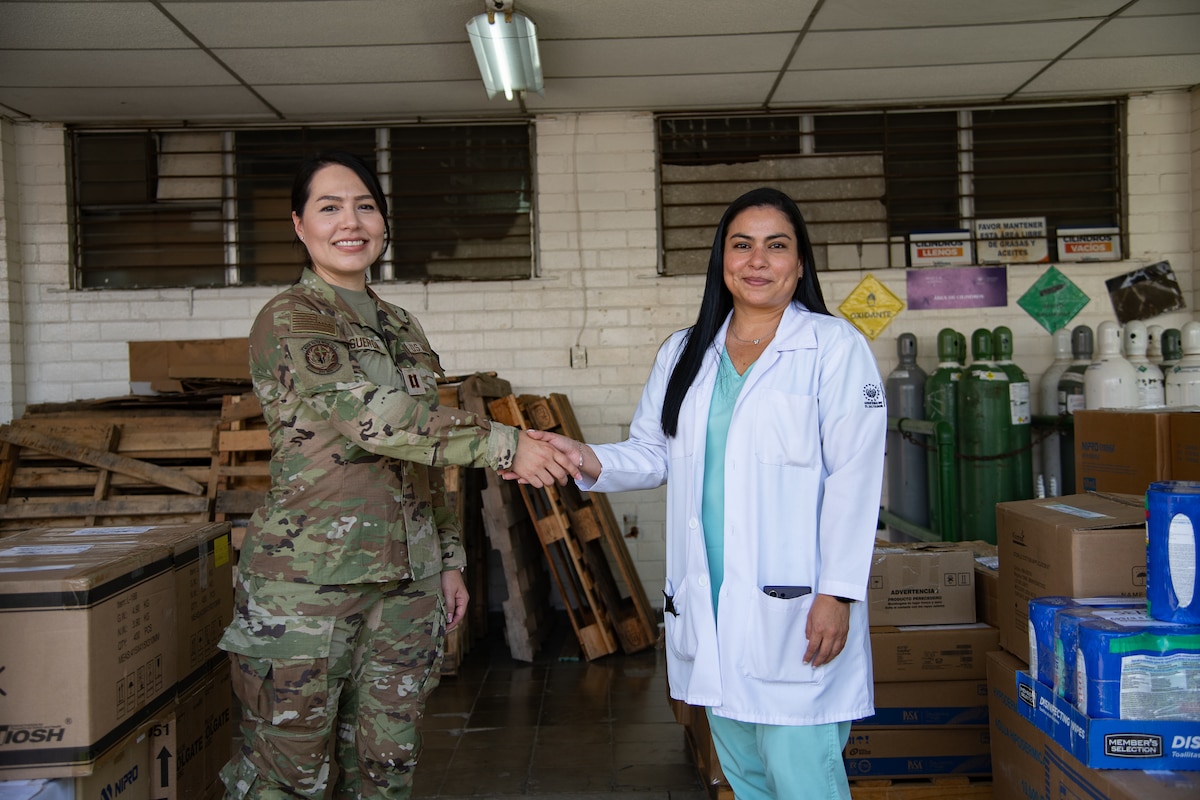 A woman in U.S. military uniform shakes hands with a doctor in civilian clothes.