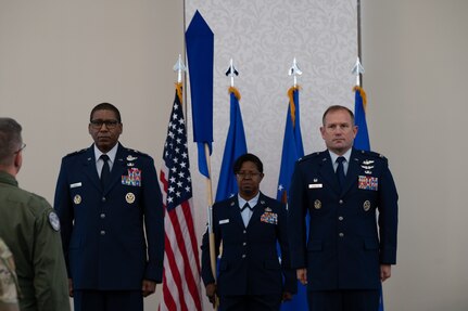 Reed, Hert and Arrington stand at attention, as Hert holds the guidon.