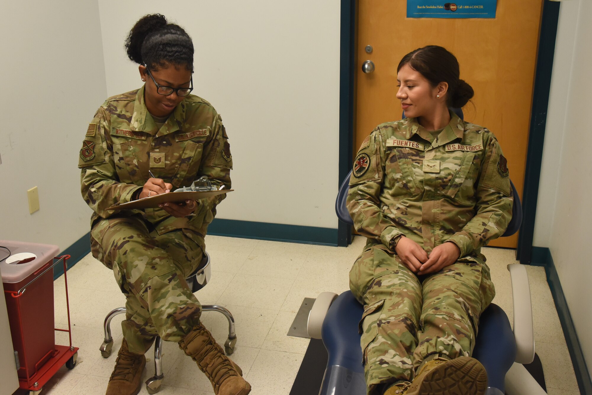 Tech Sgt. Witherspoon assists an Airman in filling out a medical questionnaire.