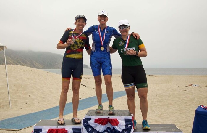 Col. Christine Houser, left, commander of Marine Corps Air Station Camp Pendleton, stands at the podium after finishing second in the Women's Masters Division during the 2024 Armed Forces Triathlon Championship at Naval Base Ventura County, Calif. Also pictured are first place finisher, Air Force Maj. Esther Willett, center; and  third place finisher Army Maj. Christyn Gaa.