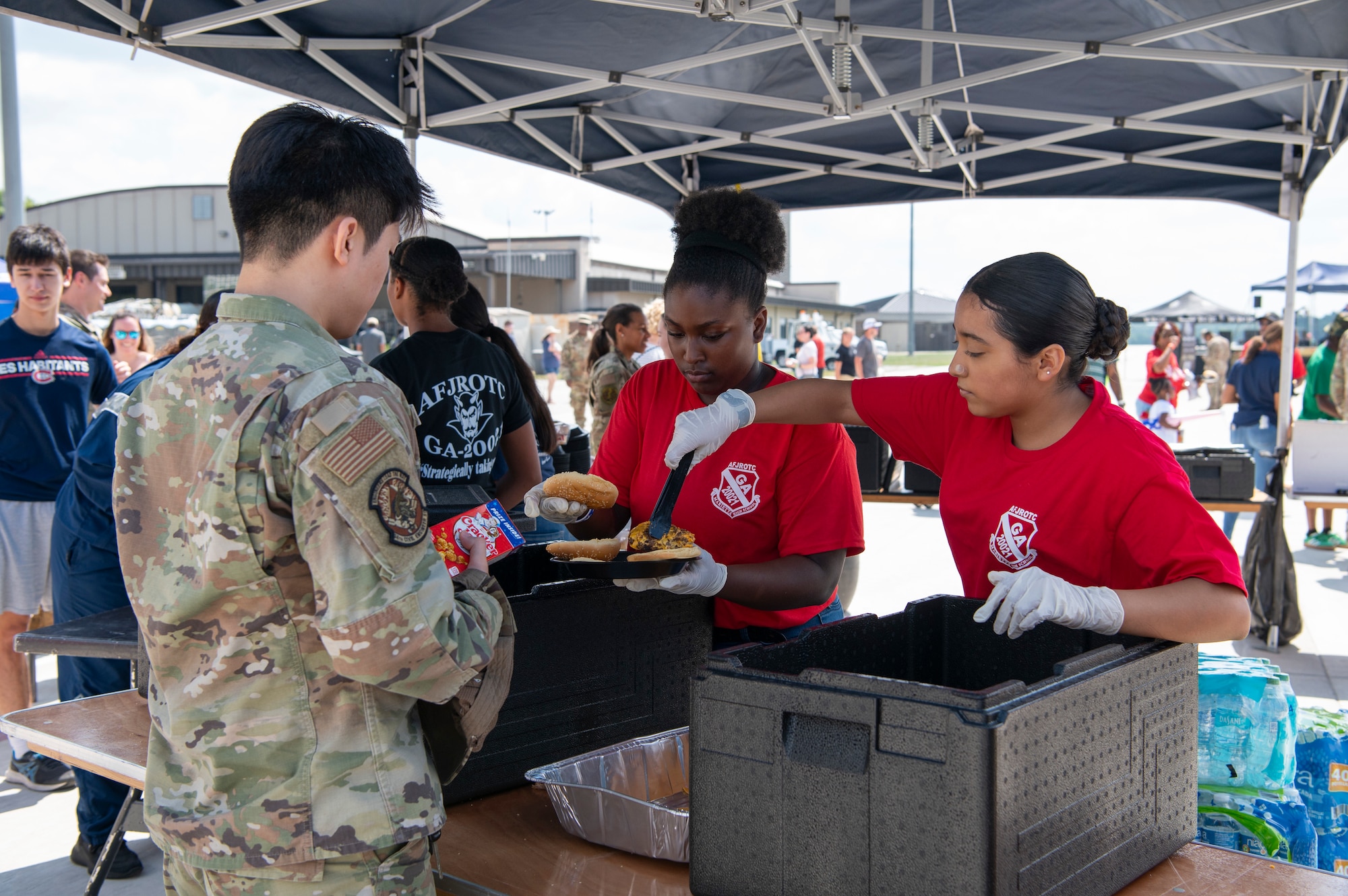 JROTC students place food on airmen and their families' trays.