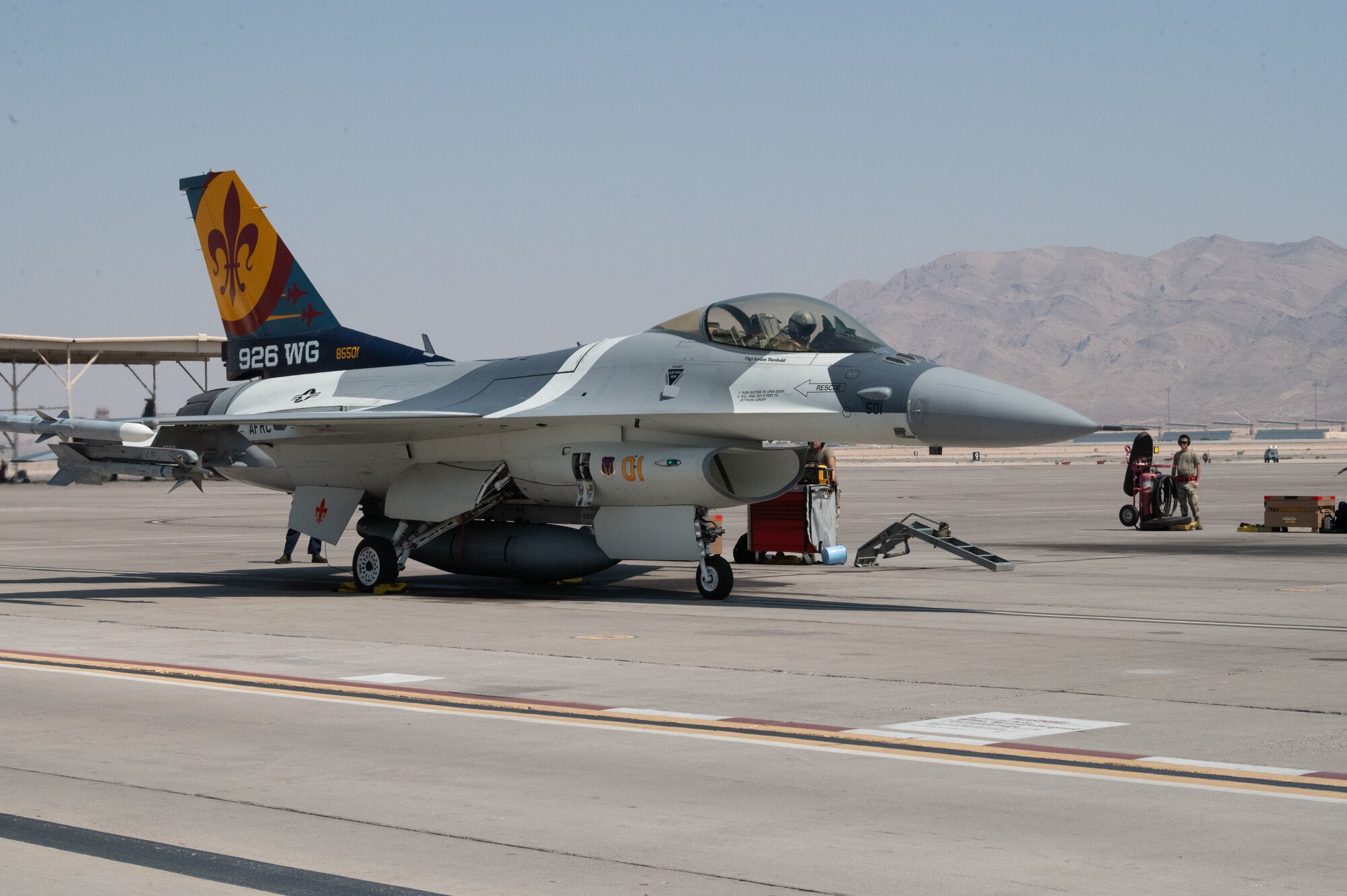 An F-16 fighter jet stands still on the flight line