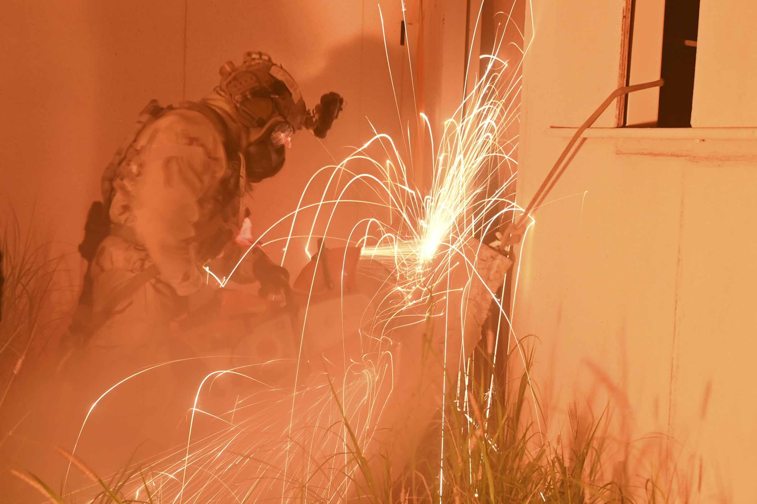 An Air Force pararescueman cuts through a barrier to extract simulated patients from a building during a training exercise at Davis-Monthan Air Force Base, Ariz., Aug. 29, 2024.