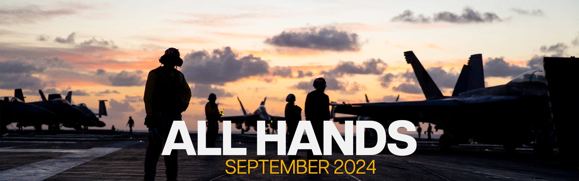 A photo of Sailors on a flight desk as the sun rises. The Sailors are silhouettes, and there are jets on the flight deck as well. The sky is a warm color, and clouds are in the sky.