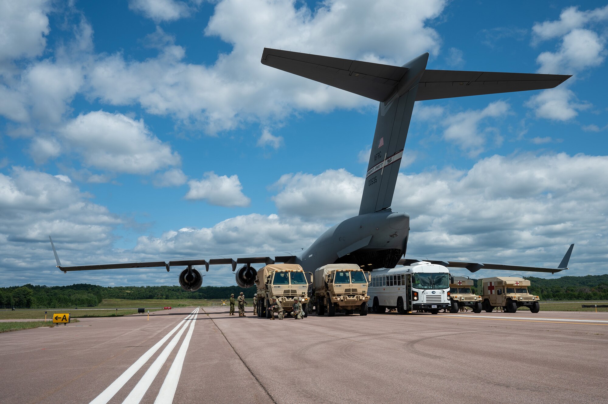 A medical convoy consisting of U.S. Air Force, joint and allied medical personnel participating in Exercise Patriot Medic 2024 line up ambulances to a 445th Airlift Wing C-17 Globemaster III assigned to Wright-Patterson Air Force Base for patient loading and unloading at Fort McCoy Army Airfield, Wisconsin, August 10, 2024. Patriot Medic leveraged specialized training opportunities and partnerships with other military branches and allies to develop combat-ready medics. (U.S. Air Force photo by Tech. Sgt. Timothy Leddick)