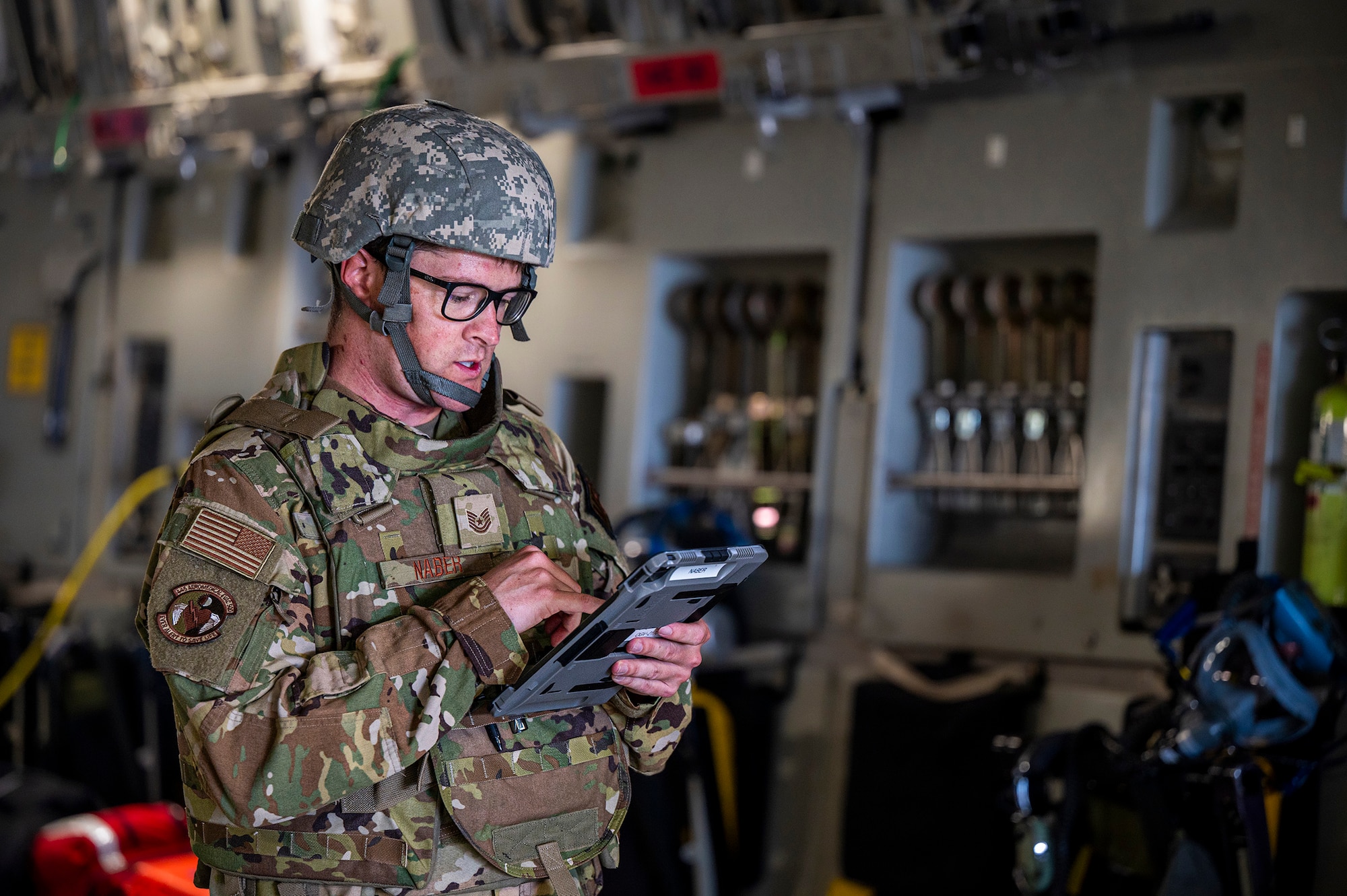 Tech. Sgt. Trey Naber, 445th Aeromedical Evacuation Squadron aeromedical technician, checks over medical information on a 445th Airlift Wing C-17 Globemaster III assigned to Wright-Patterson Air Force Base, during Exercise Patriot Medic 2024 at Fort McCoy's Army Airfield, Wisconsin, Aug. 10, 2024. This exercise assessed capability gaps within deployment platforms and identify better ways to rapidly support the warfighter around the globe. (U.S. Air Force photo by Staff Sgt. James Frit
