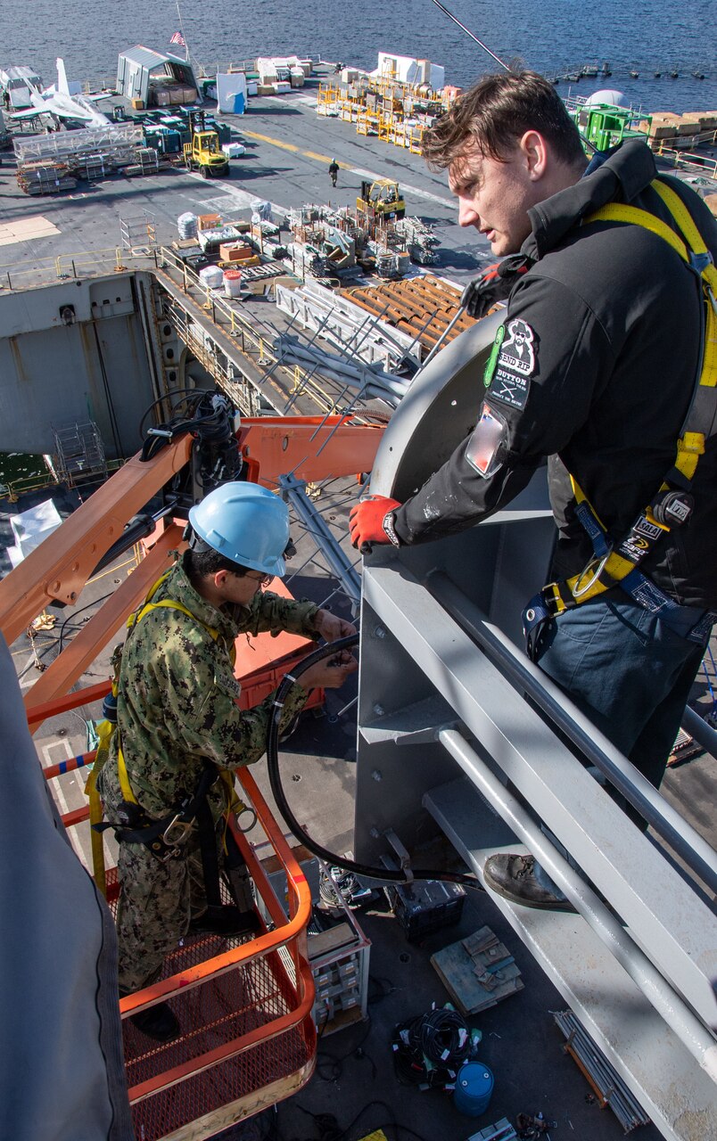 Electronics Technician 3rd Class Gage Pierson (above), from Helena, Montana, assists Information Systems Technician 2nd Class Jeffrey Salguero (below), from Palmdale, California, in the repair of an antenna aboard the aircraft carrier USS Nimitz (CVN 68) while in port at Naval Base Kitsap-Bremerton, March 26. Nimitz is in port for a scheduled planned incremental availability maintenance period.