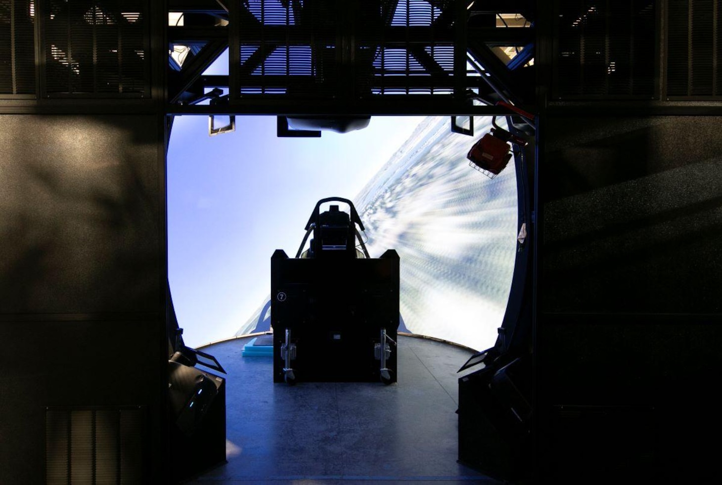 The Naval Air Warfare Center Aircraft Division’s Joint Simulation Environment is a hyper-realistic digital range that consists of F-35 Lightning, F-22 Raptor, and adversary cockpits, 4K projectors that stretch nearly 360 degrees around pilots, as well as aircraft software that enable pilots to fly wartime scenarios in a near-exact virtual battlespace. The facility also features briefing rooms where pilots review their missions before and after training to learn why they were or were not successful, and how they can improve.