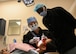 An instructor at the Air Force Oral Hygiene Course at Joint Base San Antonio-Lackland, Texas, demonstrates a dental procedure to a student at Dunn Dental Clinic on Joint Base San Antonio-Lackland, Texas Aug 28, 2024.