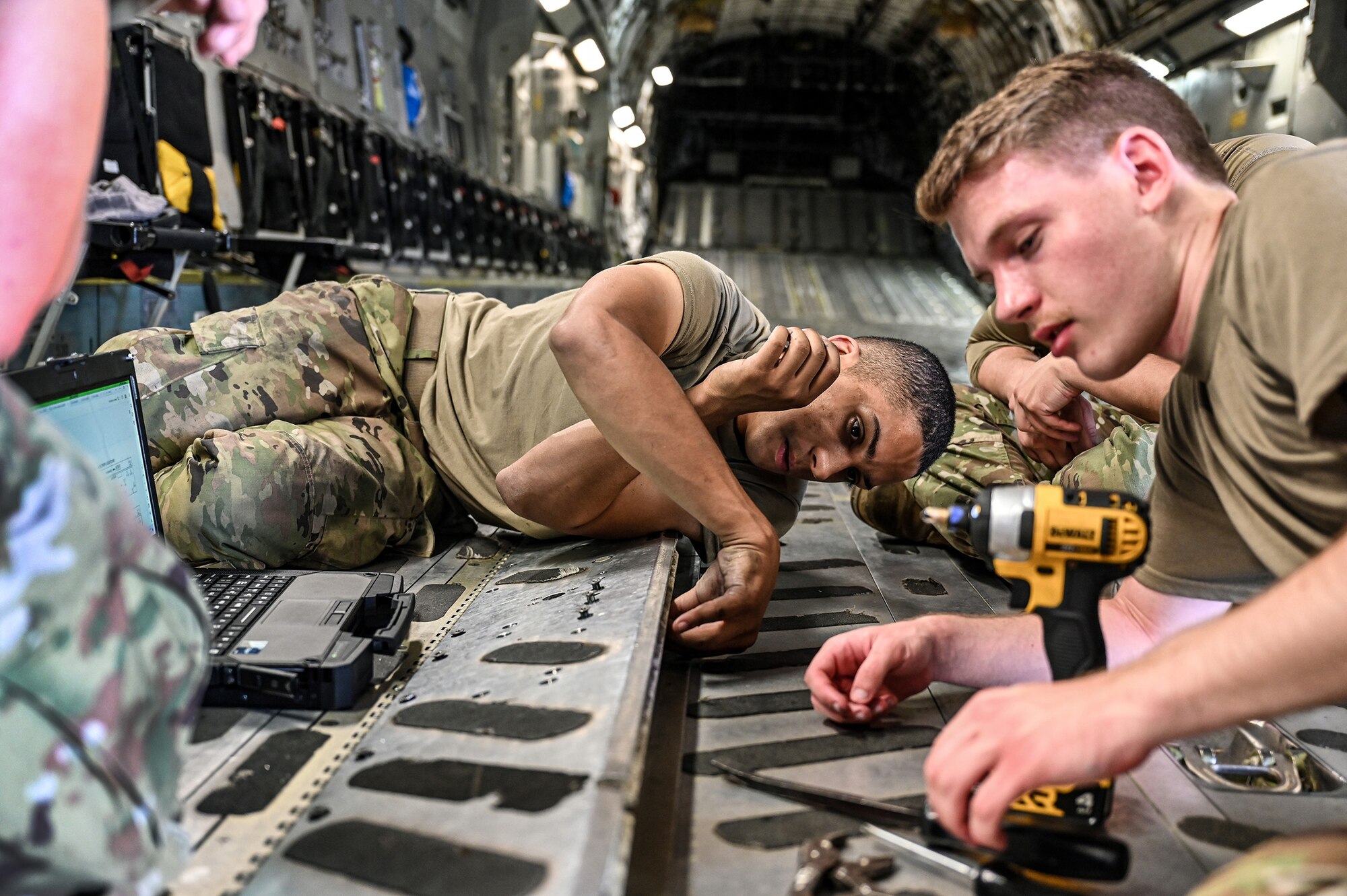 (from left to right) Senior Airmen Jorden Terry and Jonathan Zimpfer, 445th Aircraft Maintenance Squadron crew chiefs, work on a broken variable restraint assembly on a C-17 Globemaster III at Wright-Patterson Air Force Base, Ohio, Aug. 3, 2024. Broken aircraft items like this one are not only repaired by the Airmen but also used as a training tool for new crew chiefs in the unit.