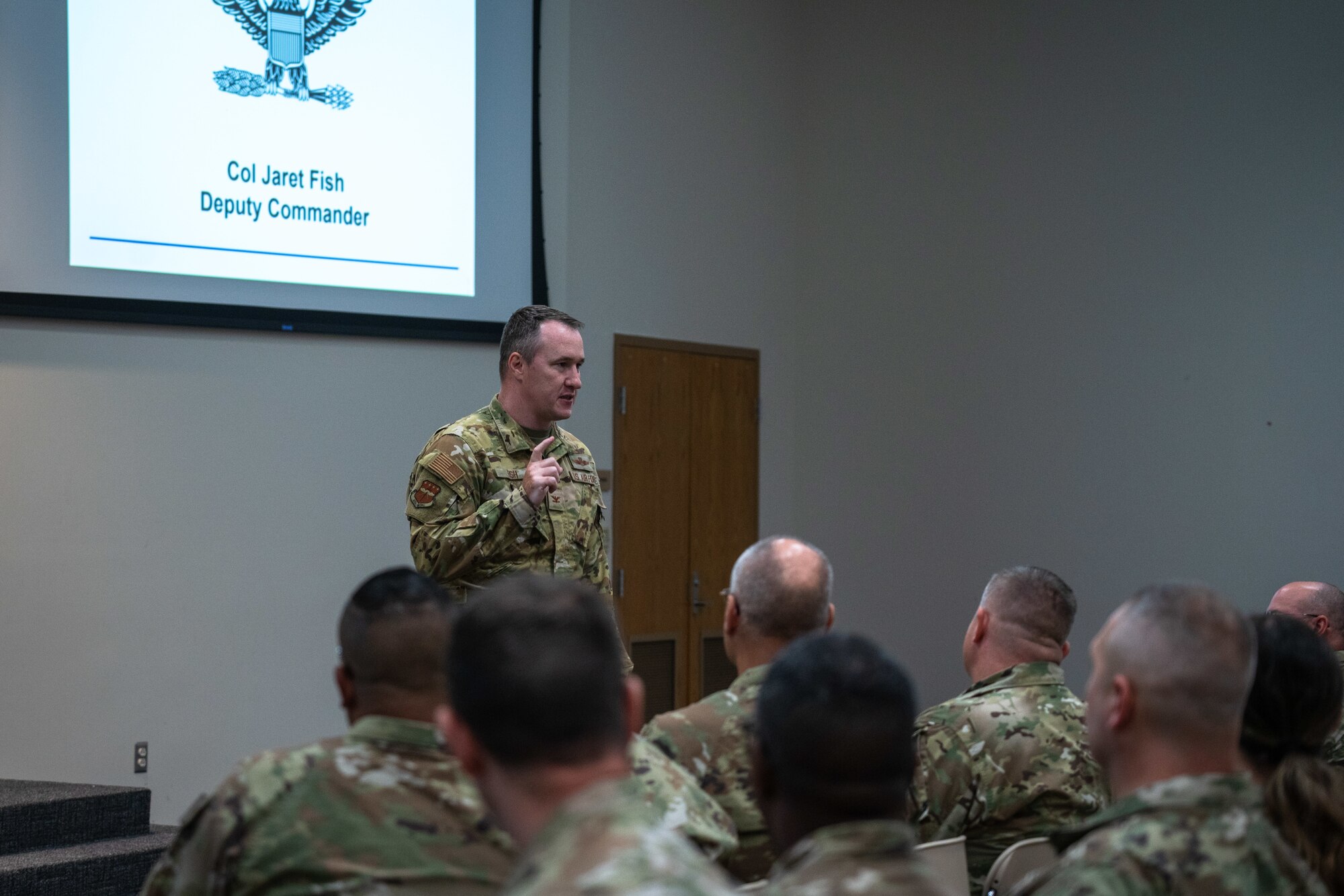 Col. Jaret Fish briefs a room full of Airmen