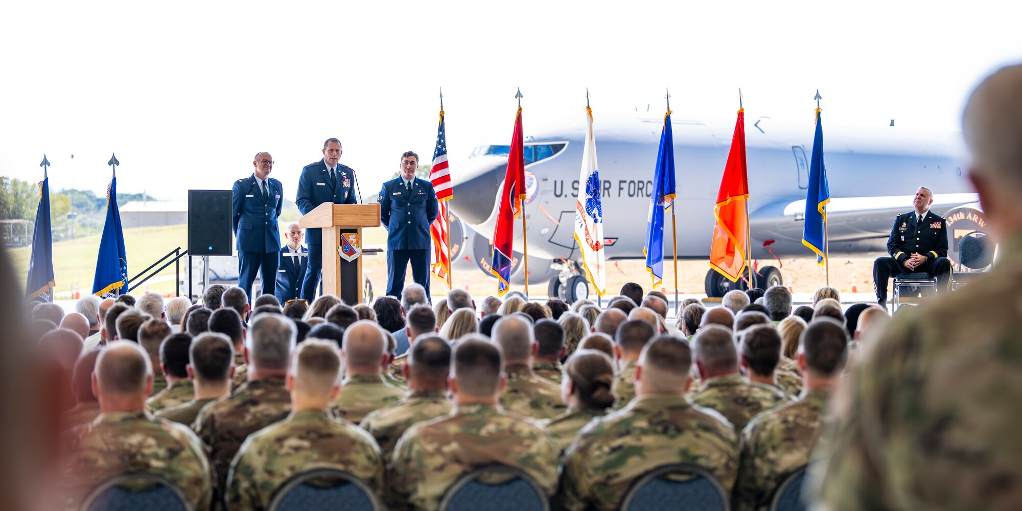Tennessee Assistant Adjutant General, Air, speaks to the audience during his promotion ceremony in an aircraft hangar.