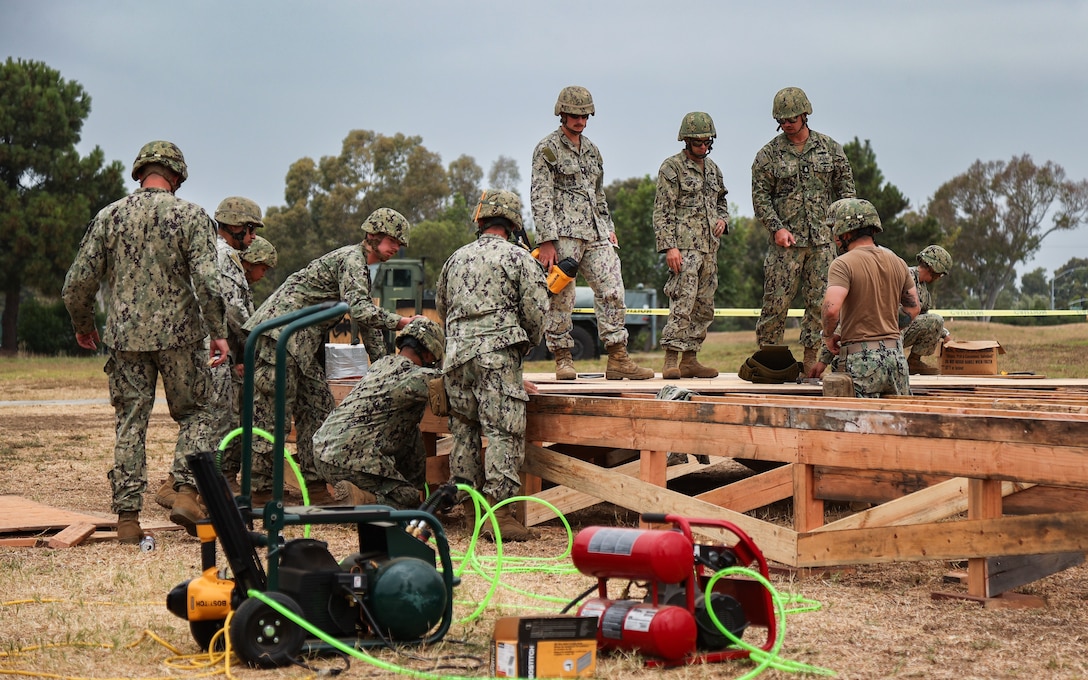 Sailors assigned to Naval Mobile Construction Battalion (NMCB) 4 construct tent decks during a Command Post Exercise (CPX) on August 24, 2024, at Naval Base Ventura County, Port Hueneme, California.