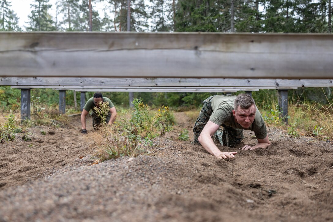 U.S. Marine Corps Cpl. Joseph Leonard, assault amphibious vehicle technician, high-crawls under an obstacle during an obstacle course at Berga Naval Base, Sweden, Aug. 30, 2024. Marines assigned to 4th Assault Amphibian Battalion, 4th Marine Division, Marine Forces Reserve, are deployed for training in support of Exercise Archipelago Endeavor, an annual integrated, Swedish Armed Forces-led exercise that increases operational capabilities between U.S. Marines and Swedish forces. (U.S. Marine Corps photo by Sgt. Scott Jenkins)
