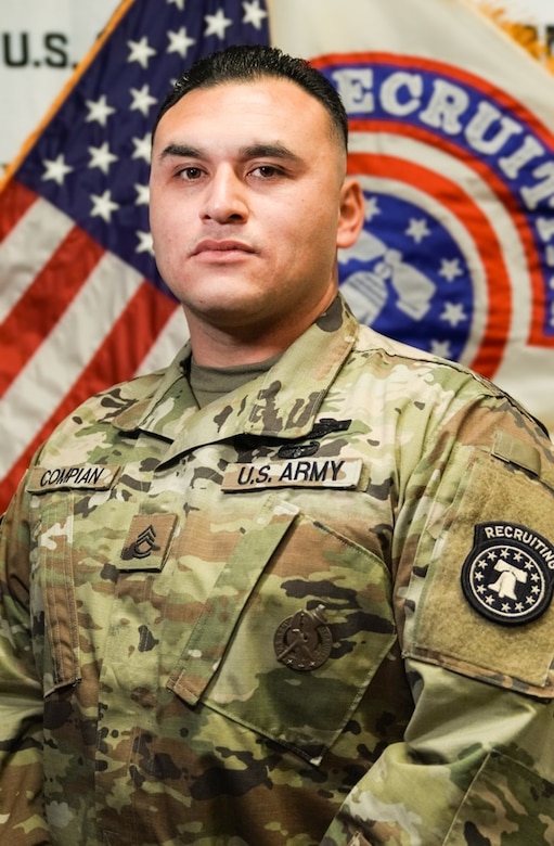 U.S. Army Soldier in uniform poses in front of American Flag and USAREC Flag for official headshot