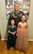 Soldier in dress uniform poses with two young girls in formal dresses