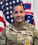 U.S. Army Soldier in uniform poses in front of the American Flag and USAREC Flag for official headshot