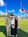 U.S. Army Soldier poses with wife and daughter in front of the American Flag and Puerto Rican Flag.