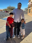 Father poses with son and daughter.