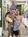 U.S. Army Soldier in uniform poses with wife, son and daughter in front of an American Flag and a USAREC Flag.