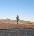 U.S. Army Soldier in PT Uniform runs on an open road