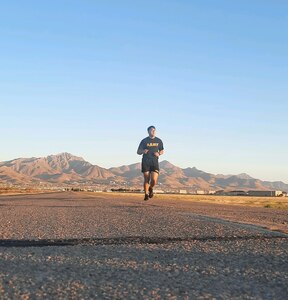 U.S. Army Soldier in PT Uniform runs on an open road