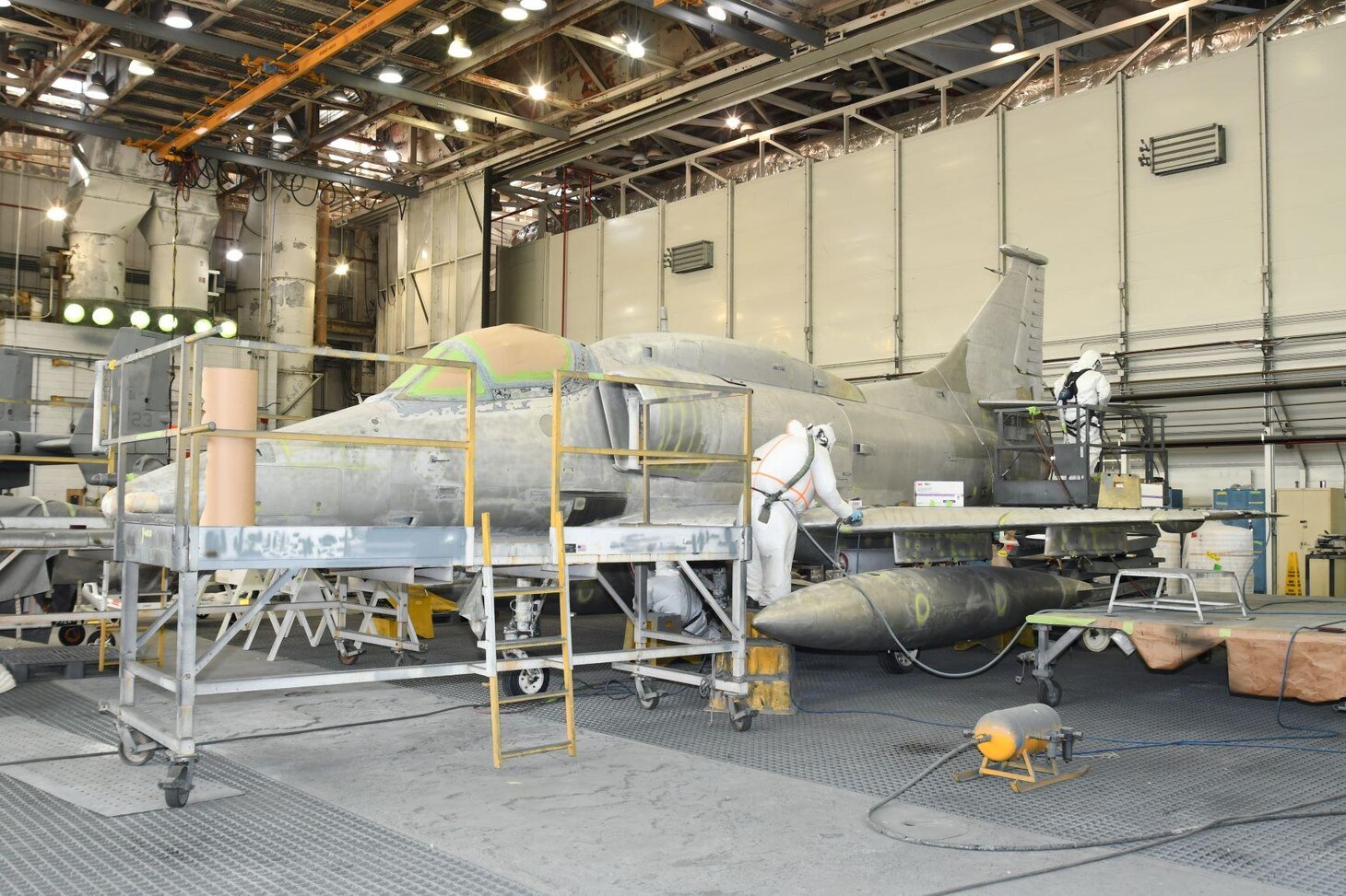 Fleet Readiness Center East Aircraft Paint Shop artisans prepare the historic Douglas A-4M Skyhawk for a fresh coat of paint by sanding the surface to remove any old paint.