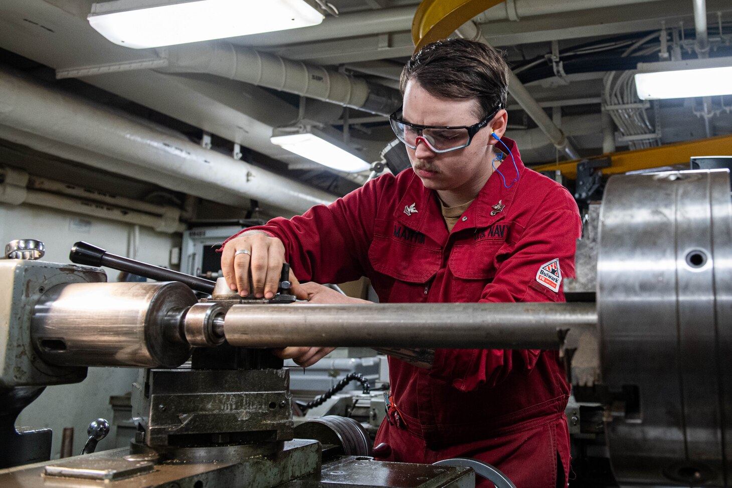 240604-N-ER894-1032 PHILIPPINE SEA (June 4, 2024) Machinery Repairman 2nd Class Kyle Martin, from Houston, adjusts a lathe before turning a piece of steel in the machine repair shop aboard the U.S. Navy’s only forward-deployed aircraft carrier, USS Ronald Reagan (CVN 76), in the Philippine Sea, June 4. Ronald Reagan, the flagship of Carrier Strike Group 5, provides a combat-ready force that protects and defends the United States, and supports alliances, partnerships and collective maritime interests in the Indo-Pacific region.