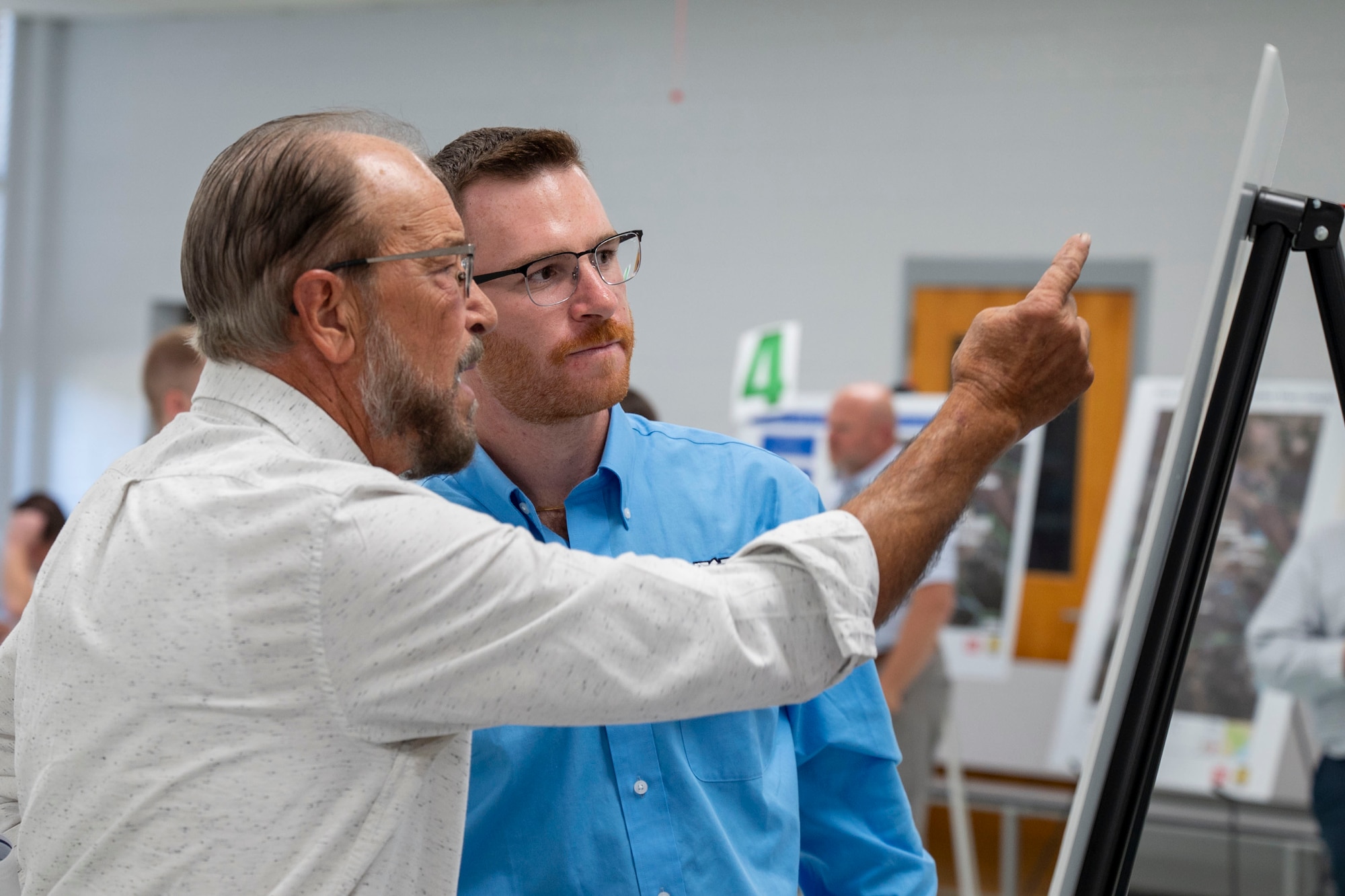 Two men discuss a graphic display.