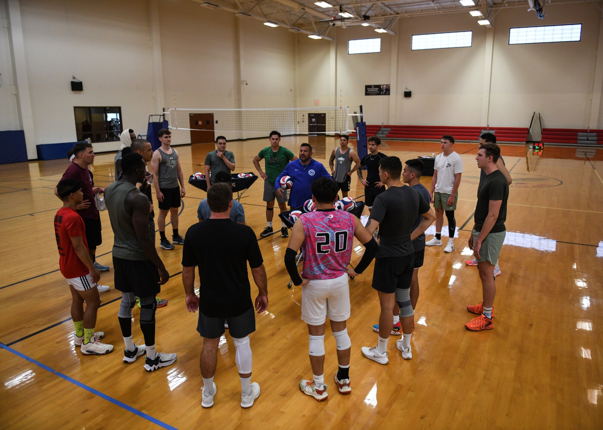 A volleyball coach speaks to his team prior to practice.