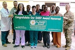 Registered nurses Rezia Lake (front left) and Holly Aguridakis (front second from left) of Walter Reed’s General Surgery Clinic, are congratulated by their General Surgical Clinic team members for recently earning the DAISY Award for Extraordinary Nurses.