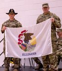 Col. (P) Lenny Williams, the Assistant Adjutant General – Army, and Commander of the Illinois Army National Guard, presents Capt. Andrew Mix, commander, Troop A, 2nd Squadron, 106th Cavalry Regiment, with a State of Illinois flag to carry with them on their deployment to the U.S. Africa Command area of responsibility.