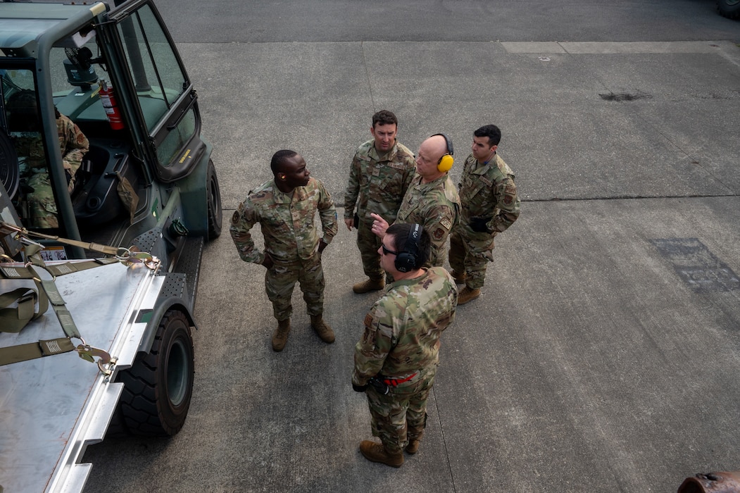 Members of the 86th the Aerial Port Squadron discuss a cargo move on Sept. 8, 2024, at Joint Base Lewis-McChord, Washington.