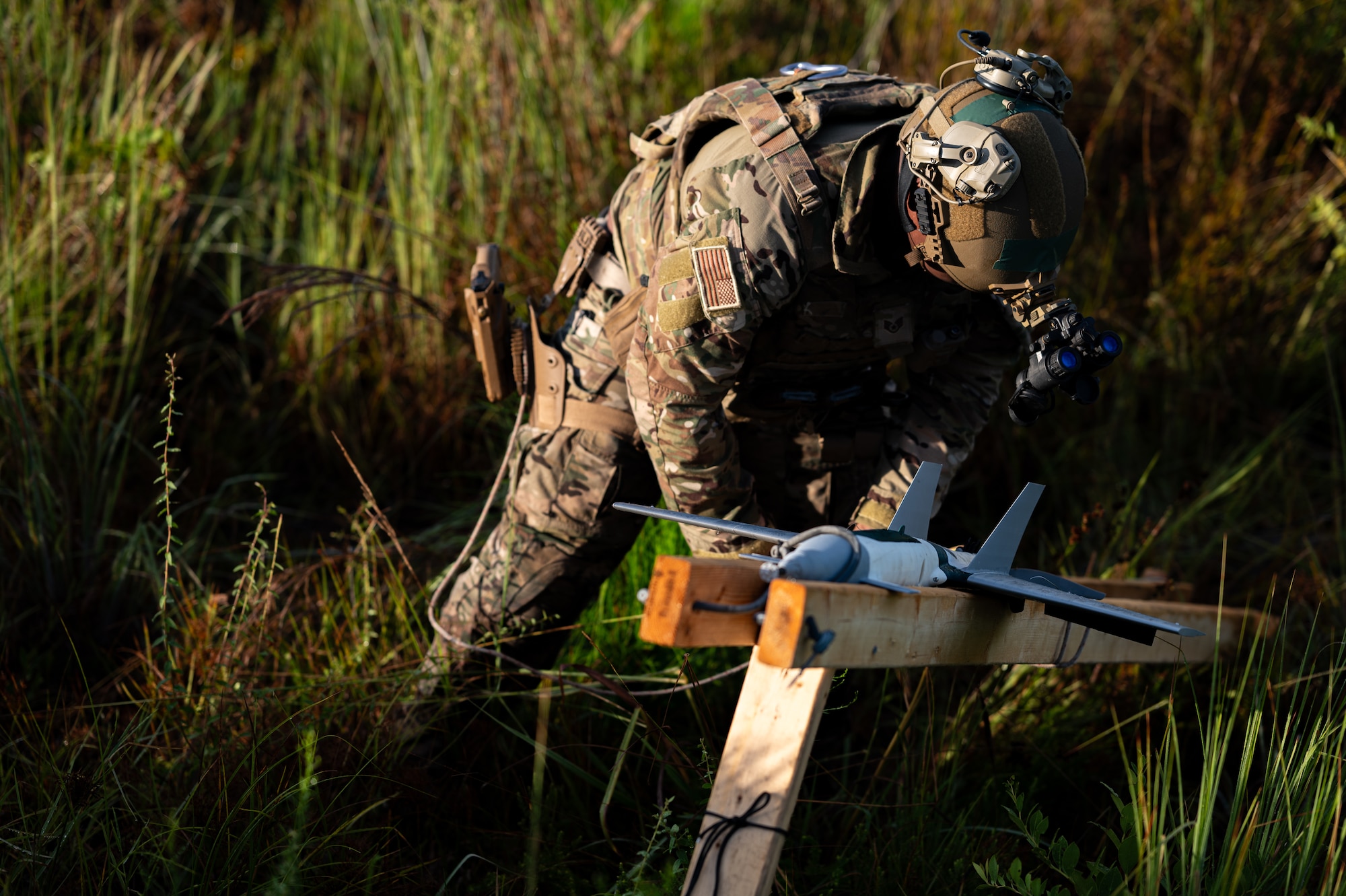 An airman attaches a rope to a rail system