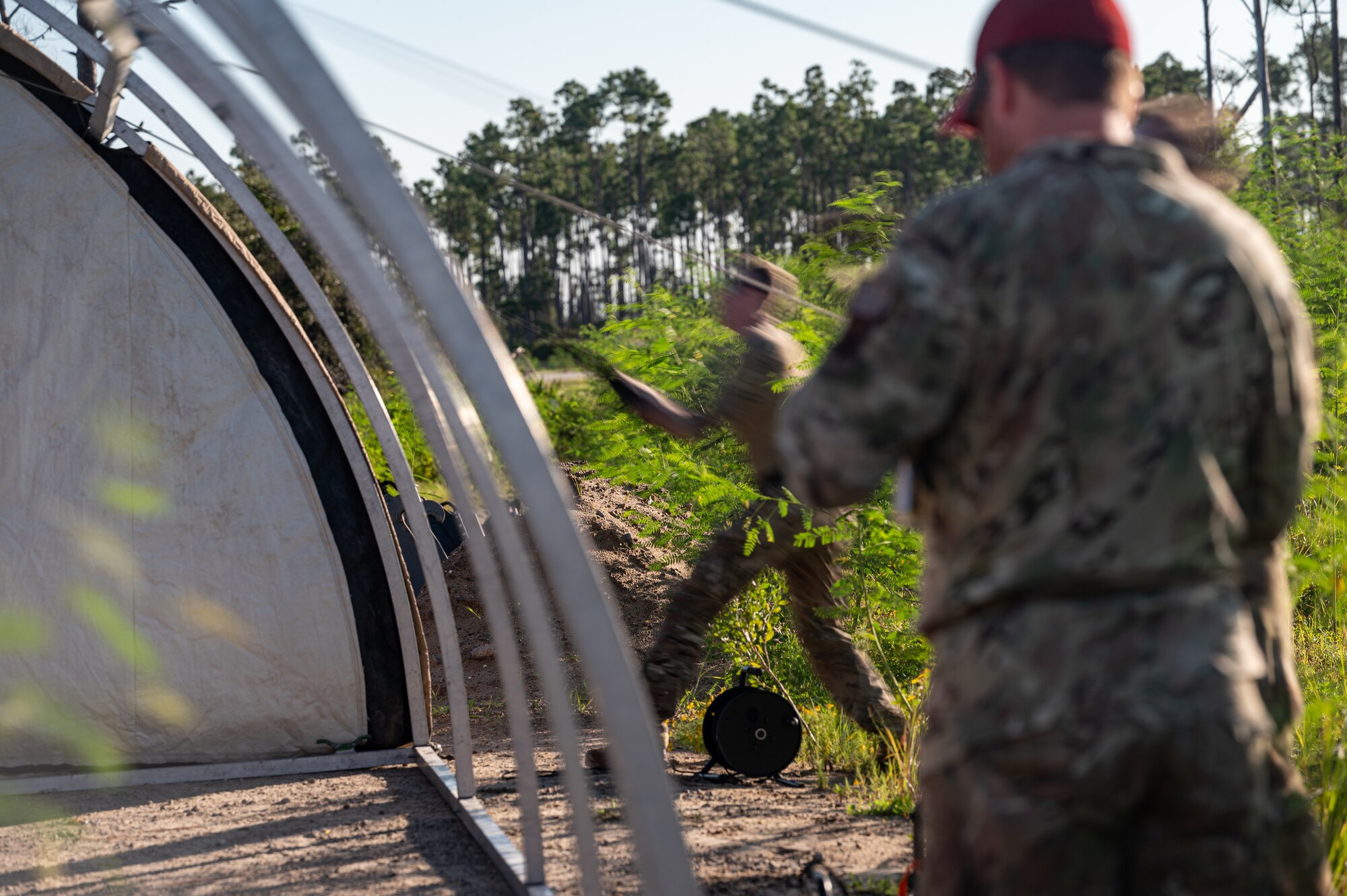 Airmen pull a tarp onto a vent