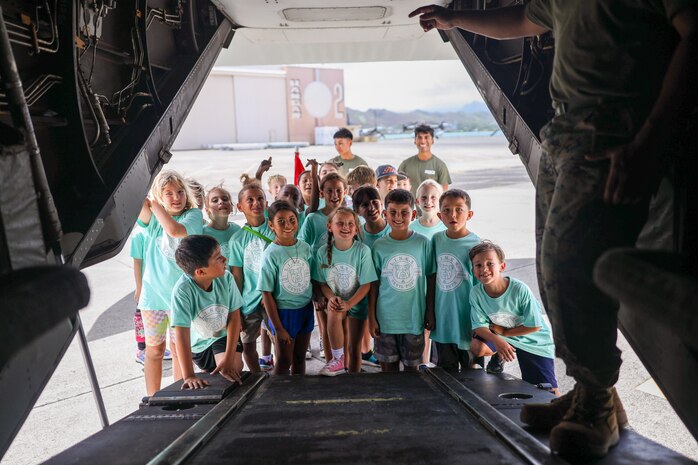 Devil Pups pose for a group photo during a Lifestyle Insights, Networking, Knowledge, and Skills workshop (LINKS) at Marine Corps Base Hawaii, Aug. 16, 2024. The LINKS program provided by Marine Corps Family Team Building included a miniature physical fitness test, water gun shooting range, vehicle and aircraft tours, and readiness brief. The Devil Pups Youth Program For America challenges, educates and helps young boys and girls of all backgrounds to learn self-confidence and responsibility for their actions. (U.S. Marine Corps photo by Lance Cpl. Samuel Estridge)