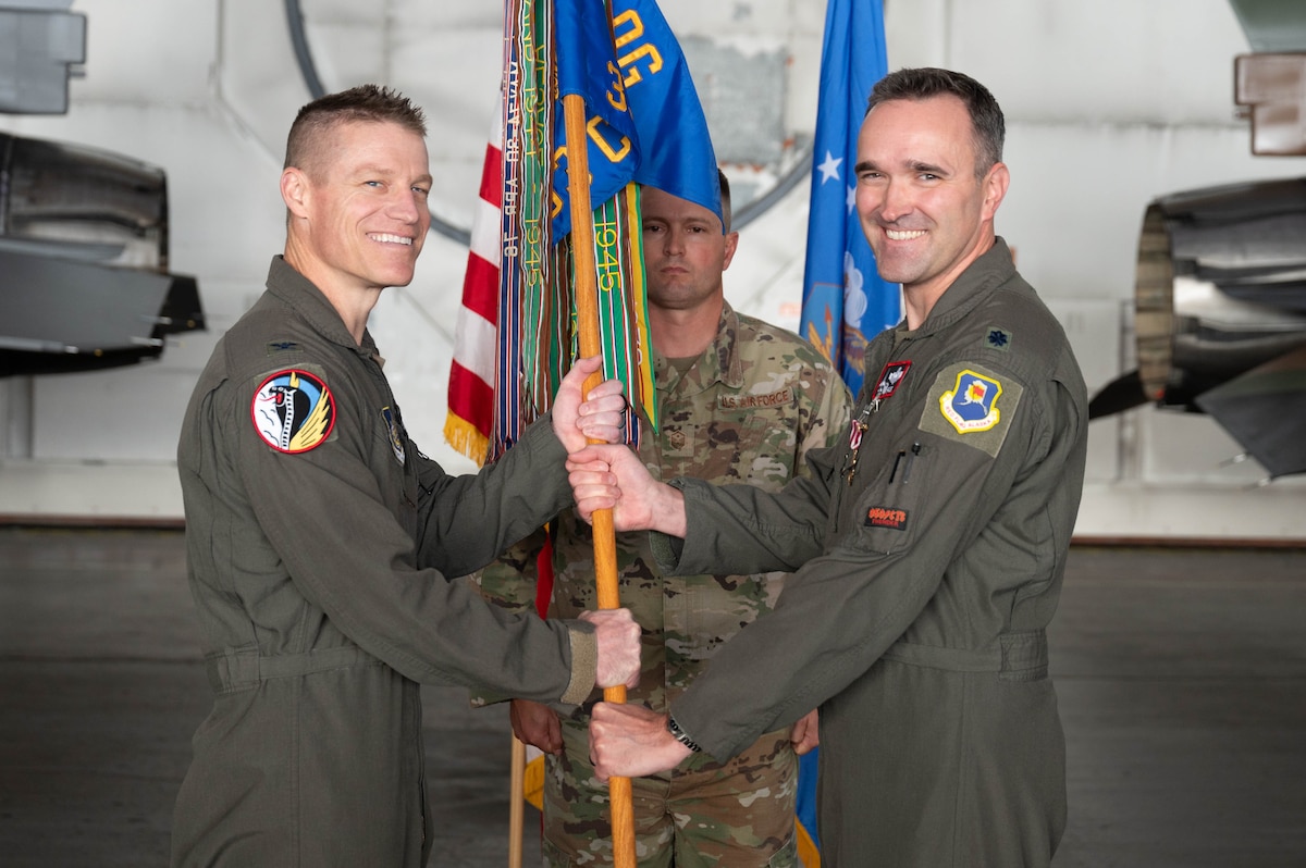 U.S. Air Force Lt. Col. James Collins II, right, 353rd Combat Training Squadron outgoing commander, relinquishes the guidon to Col. Curtis Dougherty, 354th Operations Group commander, during a change of command ceremony at Eielson Air Force Base, Alaska, Sep. 6, 2024.