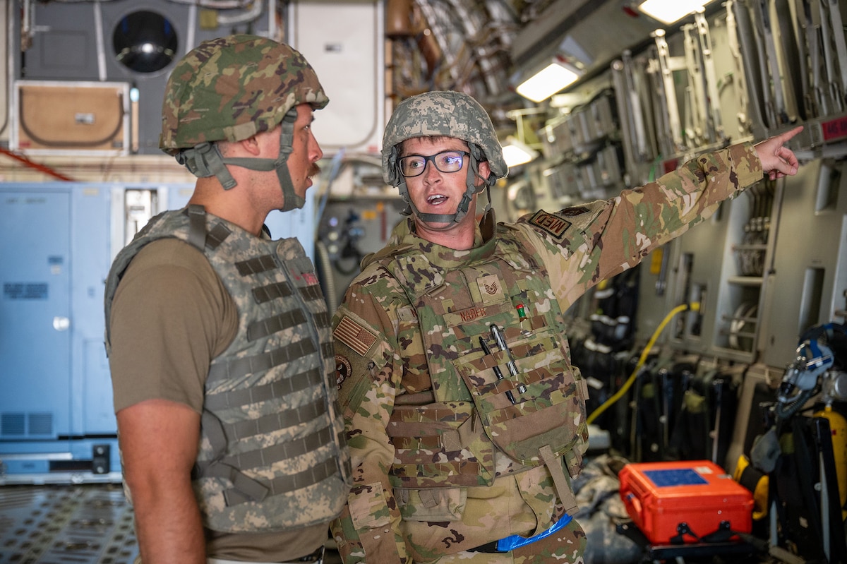 U.S. Air Force Tech. Sgt. Trey Naber, 445th Aeromedical Evacuation Squadron AE technician, right, provides a breakdown of the oxygen line setup aboard a 445th Airlift Wing C-17 Globemaster III during Exercise Patriot Medic 2024 at Fort McCoy Army Airfield, Aug. 10, 2024. The training and scenarios participants played during the exercise validated Reserve capabilities to employ en route care and use of the Theater Aeromedical Evacuation System. (U.S. Air Force photo by Tech. Sgt. Timothy Leddick)