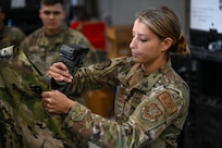 Airman 1st Class Ashlyn Levine, a supply specialist with the 157th Logistics Readiness Squadron, adds a canteen belt to an airman's mobility bag, Sept. 7, 2024, at Pease Air Force Base, New Hampshire.