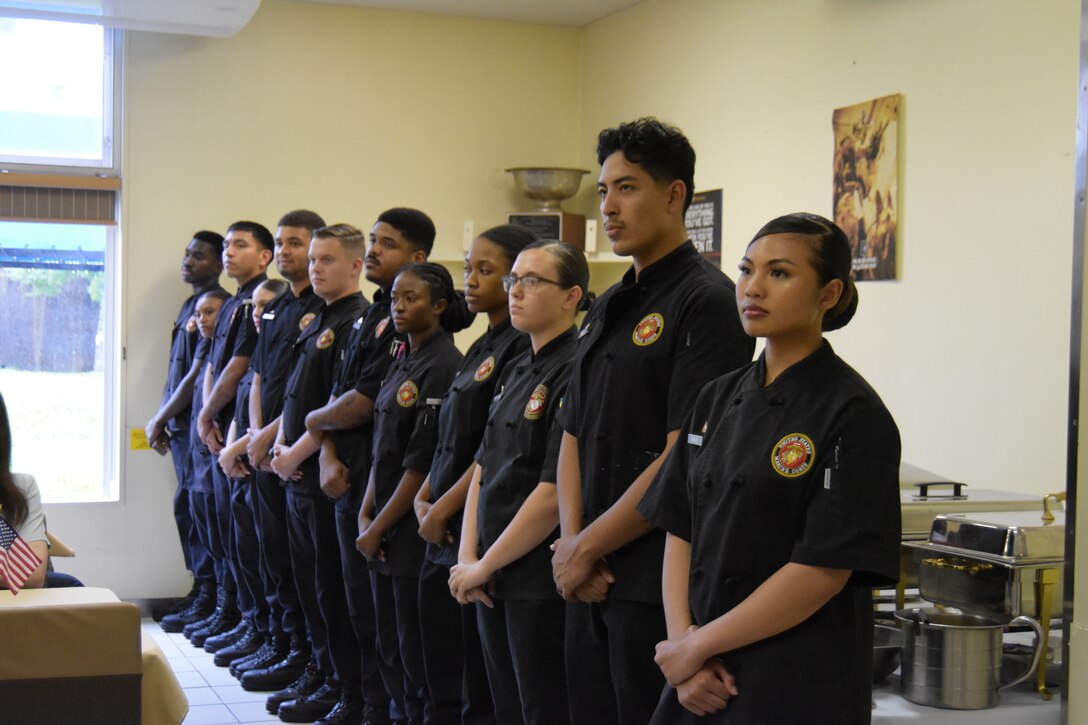 Food service Marines stand waiting to hear how their teams did at the Marine Corps Installations Pacific’s Food Services Specialist of the Quarter competition, held at Combined Arms Training Center, Camp Fuji, August 30, 2024. (U.S. Marine Corps photo by Song Jordan)