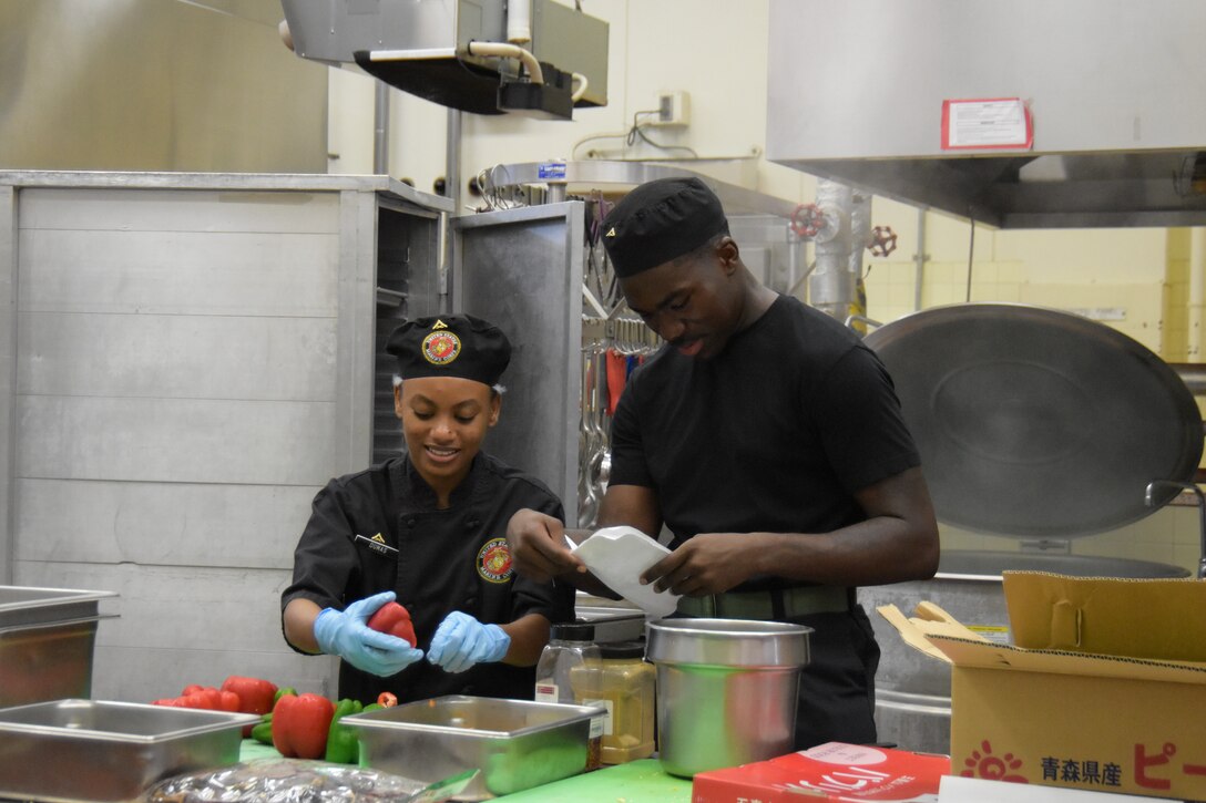 (Left to Right) Lance Cpls. Judy Dumas and Kevaughn Bernard, food service specialists assigned to Marine Corps Air Station Futemna prep on the first day of the Marine Corps Installations Pacific’s Food Services Specialist of the Quarter competition, held at Combined Arms Training Center, Camp Fuji, August 29, 2024.  (U.S. Marine Corps photo by Song Jordan)