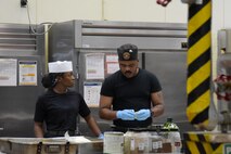 Lance Cpl. Shanera Coombs listens as Cpl. Lucky Anacletus talks, both are food service Marines assigned to Camp Kinser.