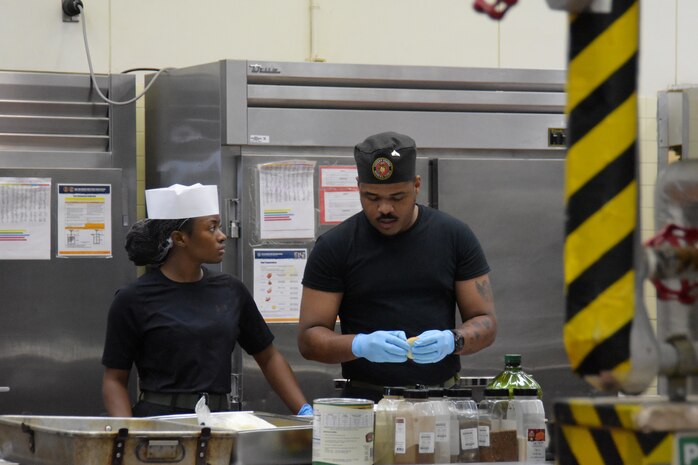 Lance Cpl. Shanera Coombs listens as Cpl. Lucky Anacletus talks, both are food service Marines assigned to Camp Kinser.