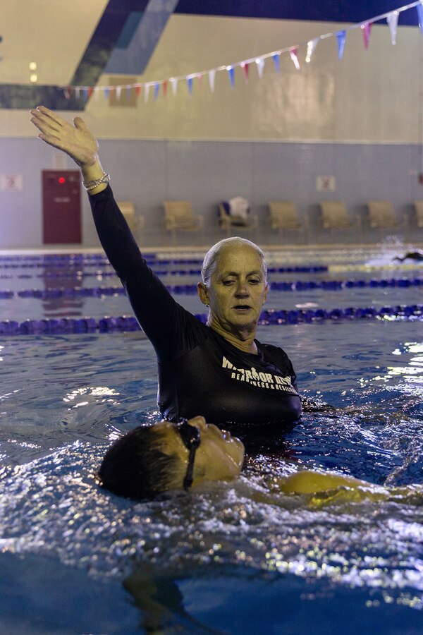Jennifer Ayers, the Marine Corps Air Station Iwakuni aquatics director and a South Carolina native, demonstrates a drill for the swim instructors in the Marine Corps Community Services’ indoor pool on Sept. 4, 2024. Ayers and the MCAS Iwakuni aquatics team provide swim clinics and master classes, and train instructors with the goal to improve service members’ survival skills and increase their water confidence. (U.S. Marine Corps photo by Sgt. Phuchung Nguyen)